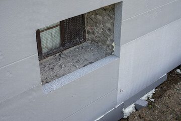 Insulation in the lower part of the house near the basement window.