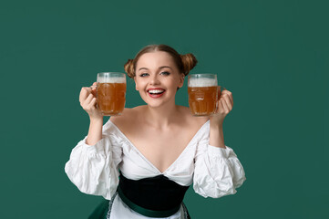 Beautiful Octoberfest waitress with beer on green background