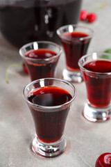 Shots with sweet cherry liqueur on grey background