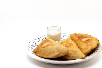 Fried empanadas stuffed with beans, meat, chicken with garlic sauce. Traditional food in Venezuela. White background, copy space, selective focus.