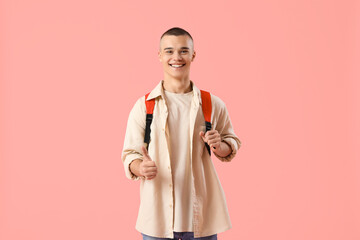 Happy male student with backpack showing thumb-up gesture on pink background - obrazy, fototapety, plakaty