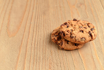 Tasty cookies with chocolate chips on wooden background