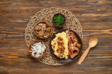 Plate of tasty banosh and ingredients on wooden background