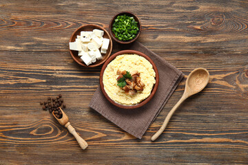 Bowl of tasty banosh and ingredients on wooden background