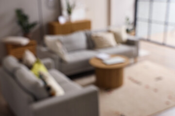 Blurred view of living room interior with grey sofas and coffee table