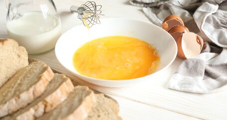 Beating eggs with a whisk in a plate. Slices of bread on a cutting board. Cooking food. A series of photos of Bread with Egg Recipe. 
