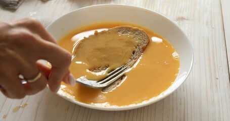 Slices of bread are soaked in beaten egg. Preparing toast before frying.. A series of photos about...