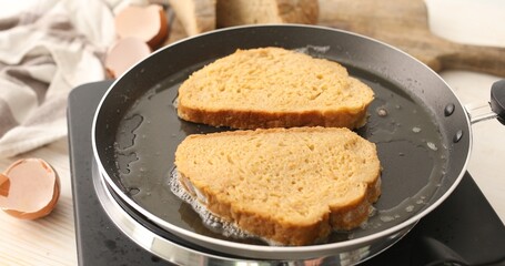 Slices of bread soaked in beaten egg are fried in a frying pan. Cooking food. A series of photos about Bread with Egg Recipe.