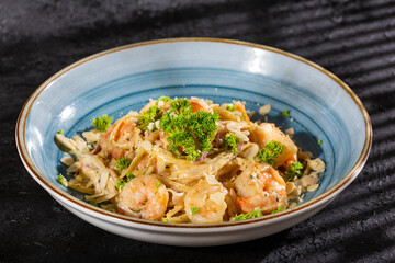 Delicious fettuccine pasta with shrimp and parsley - Dark background