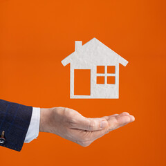 Businessman hand holding house icon - Real estate agency, buying and renting real estate