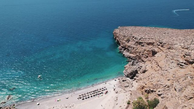 Finikas Beach resort by turquoise blue sea in the village of Loutro, drone view. High quality 4k footage
