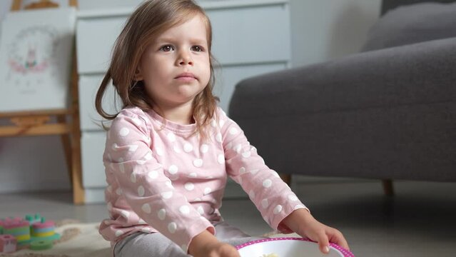One girl caucasian toddler child eat macaroni pasta at home with hands