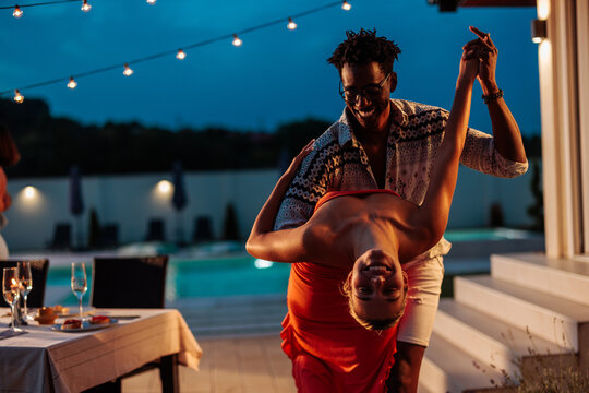 Happy couple dancing during poolside party