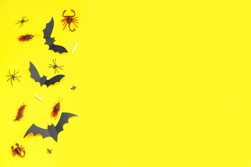 Halloween composition with candy bugs and bats on yellow background