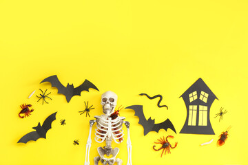 Halloween composition with candy bugs, skeleton and bats on yellow background