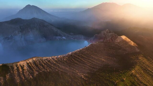 Aerial view of Kawah Ijen volcano with turquoise sulphur lake at sunrise. Panoramic view at East Java, Indonesia. Natural landscape background.