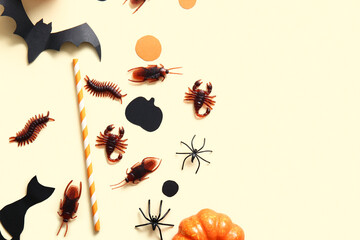 Halloween composition with candy bugs, straw and bat on beige background
