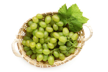 Wicker basket with fresh green grapes and leaf on white background