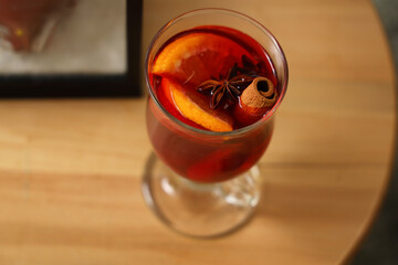 Glass of mulled wine on table in living room, closeup
