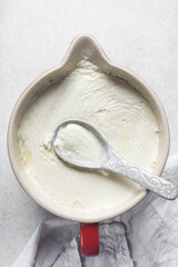 Homemade greek yogurt in a ceramic bowl, process of making Greek yogurt, strained thick yogurt in white mixing bowl