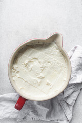 Homemade greek yogurt in a ceramic bowl, process of making Greek yogurt, strained thick yogurt in white mixing bowl