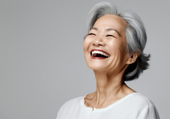 Beautiful gorgeous 50s mid age asian elderly senior model woman with grey hair laughing and smiling. Mature old lady close up portrait. Healthy face skin care beauty, skincare cosmetics, dental. - obrazy, fototapety, plakaty
