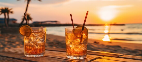 Sunset over beach with blurry drinks in view - obrazy, fototapety, plakaty