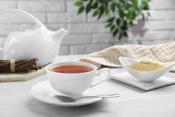 Aromatic licorice tea in cup served on white table