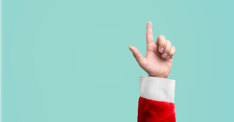 person dressed as santa claus hand pointing finger on a blue background - christmas idea concept or...