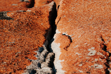 Close up of a split in an orange coloured rock face