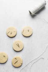 Top view of cut out rosemary sugar cookies, rosemary cookie on a white background, process of making rosemary sugar cookies