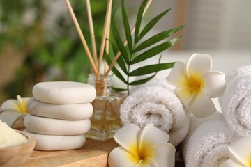 Fototapeta na wymiar Composition with different spa products and plumeria flowers on table, closeup