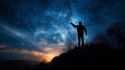 Silhouette of guy with raised arm on hill, starry night