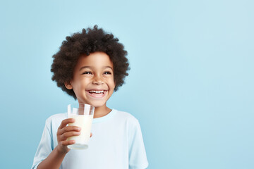African American little boy happily drinking milk isolated on blue background