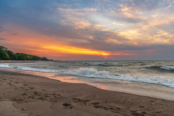 Fototapeta na wymiar kew beach in toronto's beaches neighbourhood sunrise with clouds and waves room for text