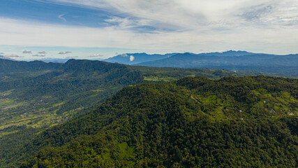 Mountain slopes with rainforest and a mountain valley with farmland. Sumatra. Indonesia.