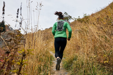 Young woman running at mountain trail
