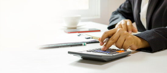 Young Asian woman's hands using a calculator, planning monthly household budget. Manage business...