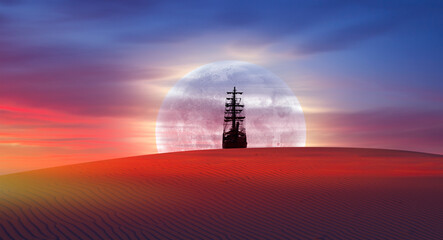 Silhouette of old ship in the desert with full moon rising at amazing sunset 