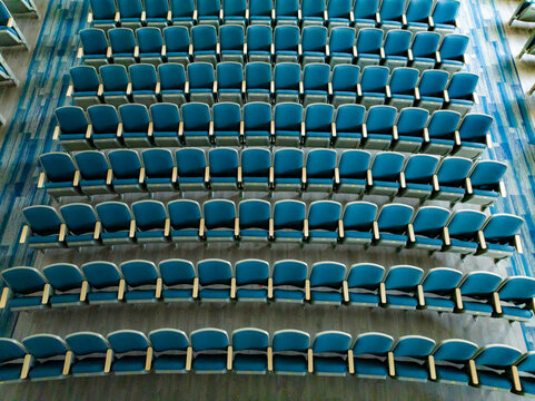 Overhead view of empty gray and blue theater, auditorium seats, chairs.