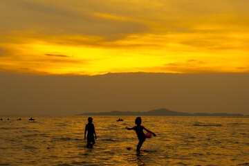 
The sea in the evening and children having fun playing in the water. The sun sets.