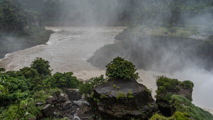 View from the observation deck of the Iguazu River. The riverbed bends between the steep banks....