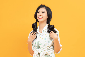 yellow background portrait of a young Asian woman with pigtails