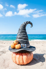 Halloween beach background with witch hat and pumpkins - 653089155
