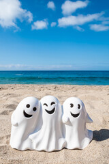 Halloween beach background with three smiling ghosts - 653089301