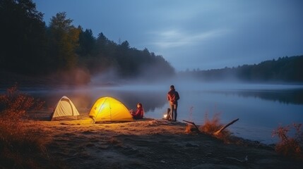 Night camping on the banks of male and female hikers There is thick fog along the river.