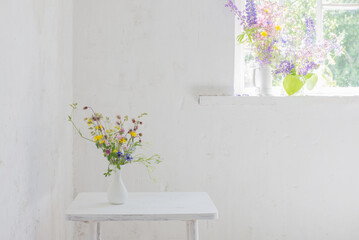 flowers in white vase in white vintage interior