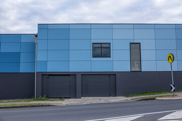A blue building with windows and doors in a commercial area.