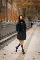 Portrait of a beautiful curly girl in the park in autumn