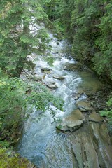 Top view of mountain river. River flows through huge blocks of stones. Enchanting wildlife of mountain amazes with its authenticity.